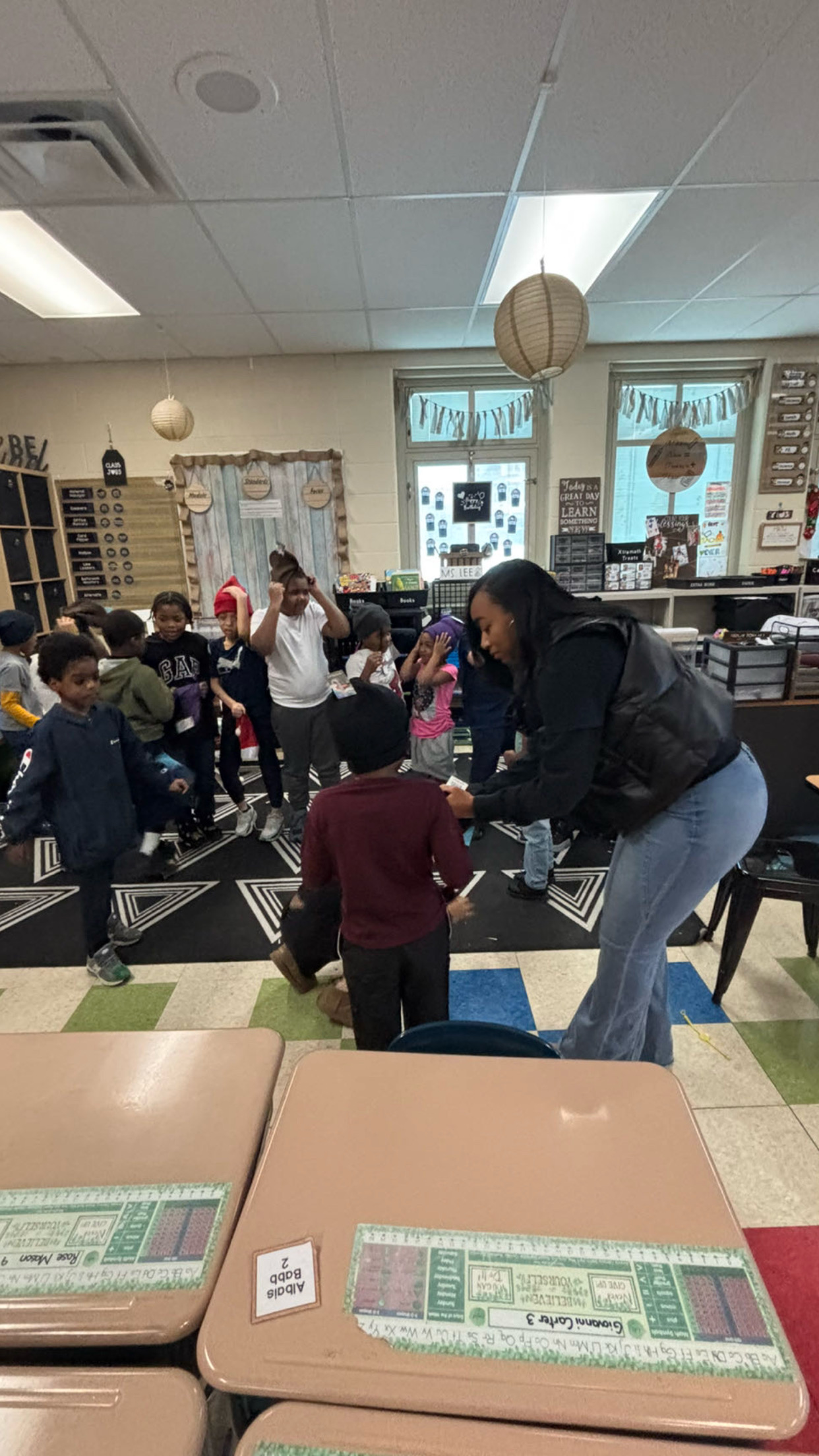 Students trying on winter hats in a classroom.